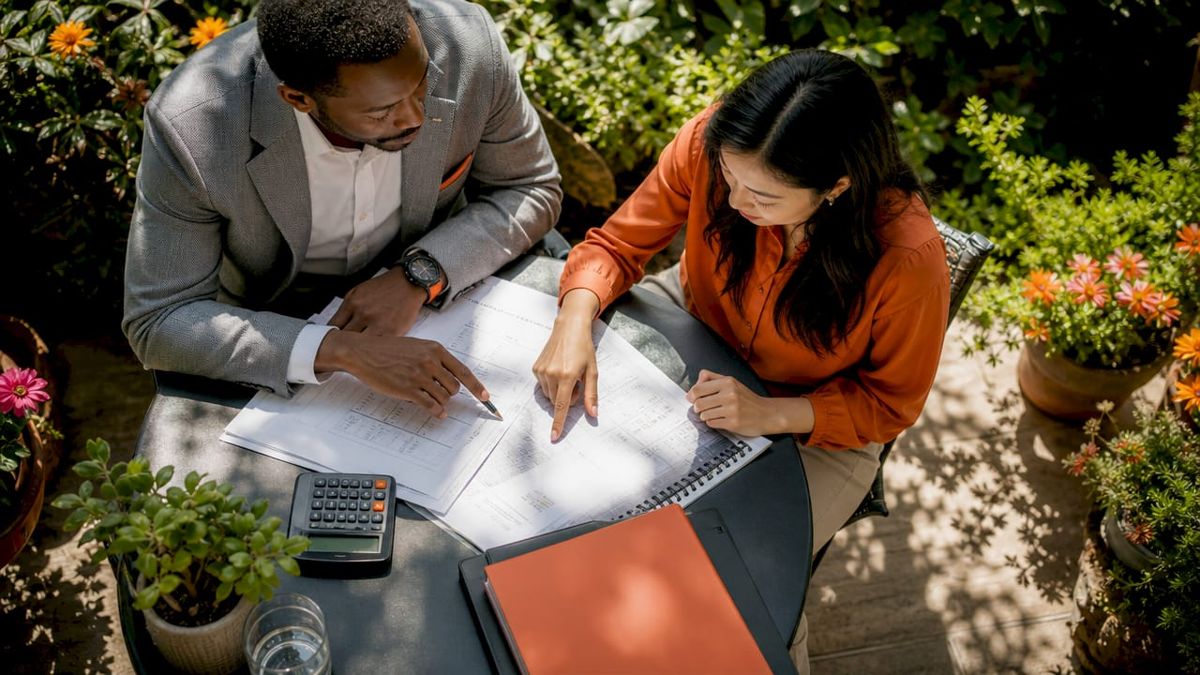 Hands exchanging construction finance documents
